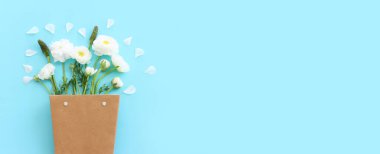 Mavi pastel arkaplan üzerindeki beyaz çiçeklerin üst görünümü