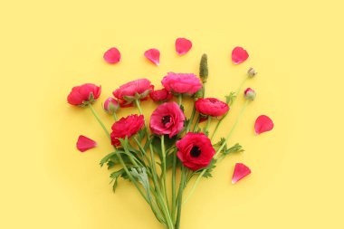 Sarı arkaplan üzerindeki pembe çiçeklerin üst görünümü