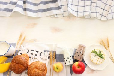 Süt ürünlerinin beyaz ahşap zemin üzerindeki en iyi görüntüsü. Yahudi bayramının sembolleri - Shavuot