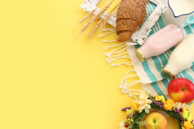 Süt ürünlerinin sarı arkaplandaki en üst görüntüsü. Yahudi bayramının sembolleri - Shavuot