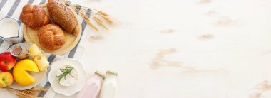 Süt ürünlerinin beyaz ahşap zemin üzerindeki en iyi görüntüsü. Yahudi bayramının sembolleri - Shavuot