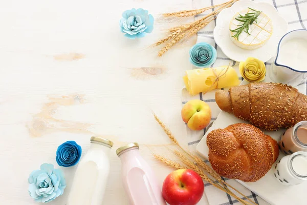白い木製の背景に乳製品のトップビューの写真 ユダヤ教の祝日のシンボル Shavuot — ストック写真