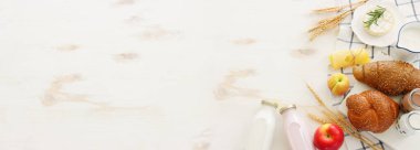 Süt ürünlerinin beyaz ahşap zemin üzerindeki en iyi görüntüsü. Yahudi bayramının sembolleri - Shavuot