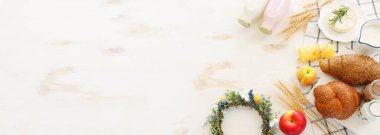 Süt ürünlerinin beyaz ahşap zemin üzerindeki en iyi görüntüsü. Yahudi bayramının sembolleri - Shavuot