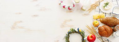 Süt ürünlerinin beyaz ahşap zemin üzerindeki en iyi görüntüsü. Yahudi bayramının sembolleri - Shavuot