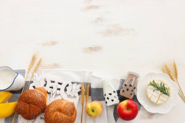 Süt ürünlerinin beyaz ahşap zemin üzerindeki en iyi görüntüsü. Yahudi bayramının sembolleri - Shavuot