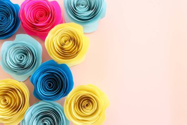 Renkli kağıt çiçeklerin üst görünüm kompozisyonu üzerine pastel pembe arkaplan
