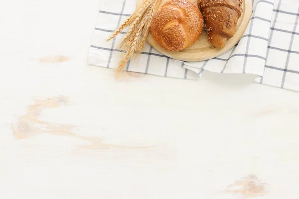 木制白色背景上的面包和面包 — 图库照片