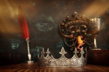 Güzel bir kraliçe ya da kral tacının ve eski bir kitabın gösterişsiz görüntüsü. fantezi ortaçağ dönemi