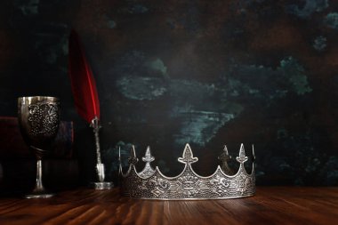 Güzel bir kraliçe ya da kral tacının ve eski bir kitabın gösterişsiz görüntüsü. fantezi ortaçağ dönemi