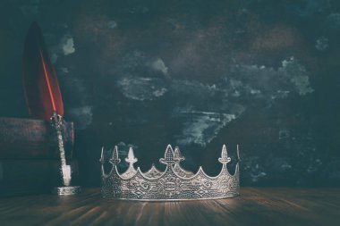 Güzel bir kraliçe ya da kral tacının ve eski bir kitabın gösterişsiz görüntüsü. fantezi ortaçağ dönemi