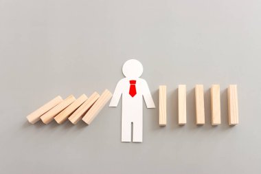 Domino etkisini durduran bir erkek figürü. resim yöneticisi ve risk kontrol kavramı