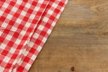 Ahşap zemin üzerinde kırmızı kareli masa örtüsü üst görünümü