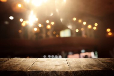 Soyut bulanık restoran ışıklarının önündeki ahşap masanın arkaplan resmi