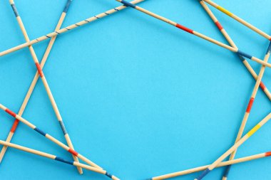Mavi arka planda Mikado oyunu. Grafik görüntüsü ve geometrik çerçeve oluşturan tahta çubuklar