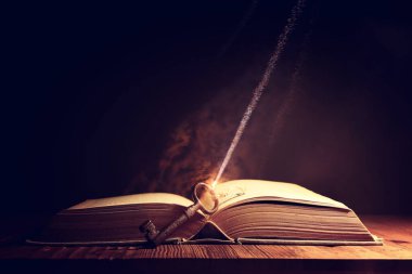 Eski anahtarlı ahşap masadaki açık antika kitap görüntüsü