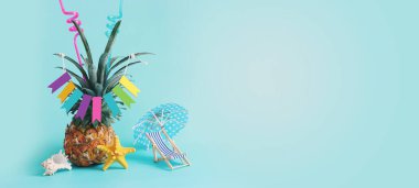 Olgun ananaslı, şemsiyeli ve mavi arka planda plaj sandalyesi olan bir görüntü. Yaz tatili ve tropikal tema