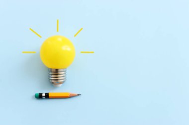 Eğitim konsepti imajı. Yaratıcı fikir ve yenilik. Mavi arkaplan üzerinde ampul metaforu