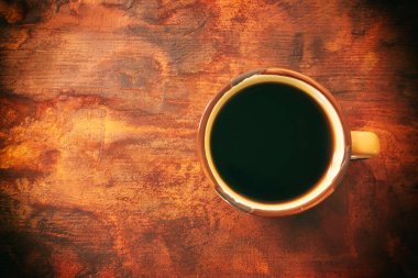 Ahşap masa arkasındaki kahve fincanının üst görüntüsü.