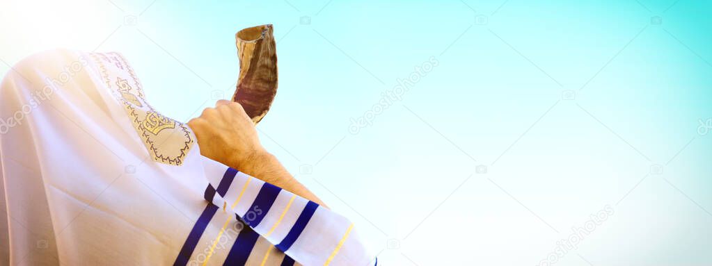Jewish man blowing the Shofar (horn) of Rosh Hashanah (New Year). Religious symbol.