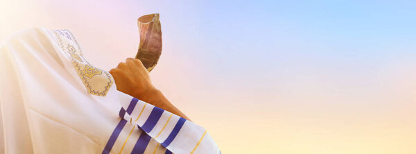 Jewish man blowing the Shofar (horn) of Rosh Hashanah (New Year). Religious symbol