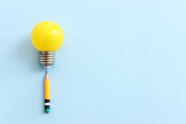 Eğitim konsepti imajı. Yaratıcı fikir ve yenilik. Mavi arkaplan üzerinde ampul metaforu