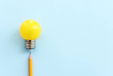 Eğitim konsepti imajı. Yaratıcı fikir ve yenilik. Mavi arkaplan üzerinde ampul metaforu