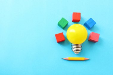 Eğitim konsepti imajı. Yaratıcı fikir ve yenilik. Mavi arkaplan üzerinde sarı ampul