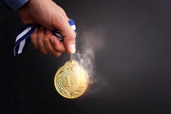 Männliche Hand Hält Goldene Medaille Vor Dunklem Hintergrund Und Licht — Stockfoto