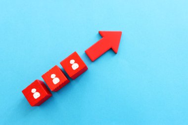 Kırmızı ok ve insan ikonlu küpler. Liderlik ve büyüme kavramı