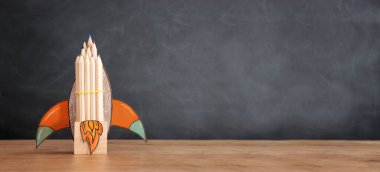 Eğitim. Ahşap masa ve karatahta arka plan üzerinden okul konseptine geri dönelim