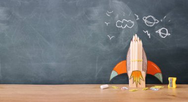 Eğitim. Ahşap masa ve karatahta arka plan üzerinden okul konseptine geri dönelim