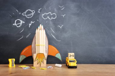 Eğitim. Ahşap masa ve karatahta arka plan üzerinden okul konseptine geri dönelim