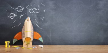 Eğitim. Ahşap masa ve karatahta arka plan üzerinden okul konseptine geri dönelim