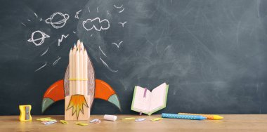 Eğitim. Ahşap masa ve karatahta arka plan üzerinden okul konseptine geri dönelim