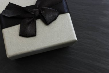 Koyu renkli arka planda gri hediye kutusu. Üst görünüm