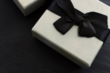 Koyu renkli arka planda gri hediye kutusu. Üst görünüm