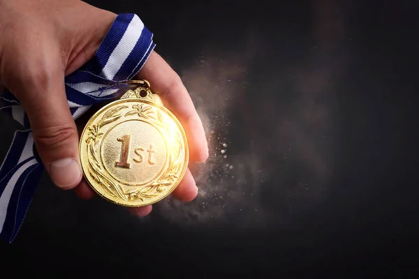 Männliche Hand Hält Goldene Medaille Vor Dunklem Hintergrund Und Licht — Stockfoto