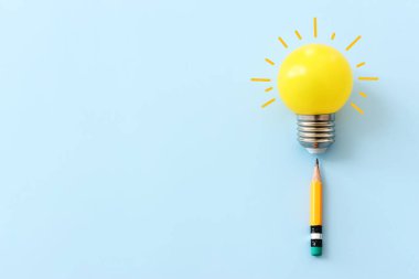 Eğitim konsepti imajı. Yaratıcı fikir ve yenilik. Mavi arkaplan üzerinde ampul metaforu