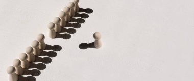 Farklı düşünme ve yaratıcılığı bulma imajını kavra. Tahta figürler duvar oluştururken, bir kişi farklı yönleri işaret ediyor.