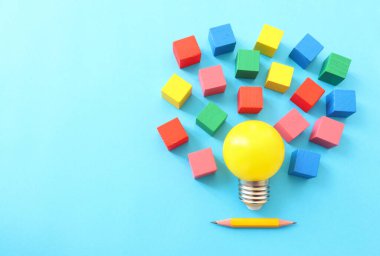 Eğitim konsepti imajı. Yaratıcı fikir ve yenilik. Mavi arkaplan üzerinde sarı ampul