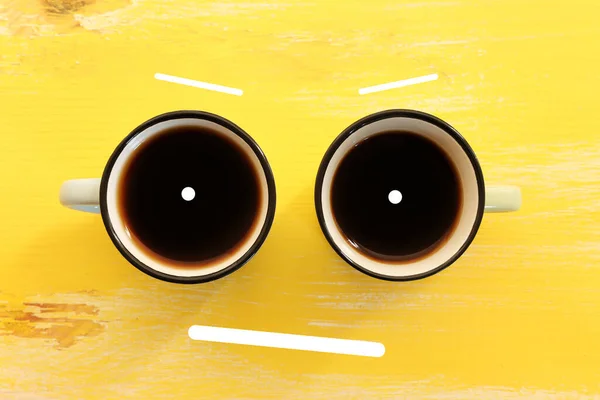 Top View Image Coffee Cups Smiling Face Yellow Wooden Table — стоковое фото