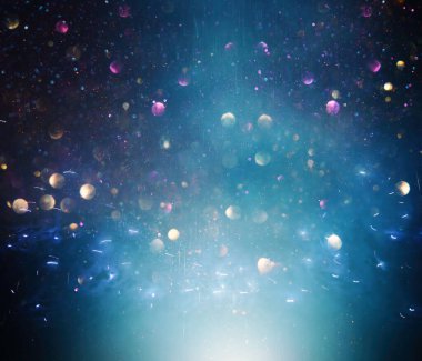 Soyut siyah, altın ve mavi parıltılı ışıkların arkaplanı. Odaklanamadı