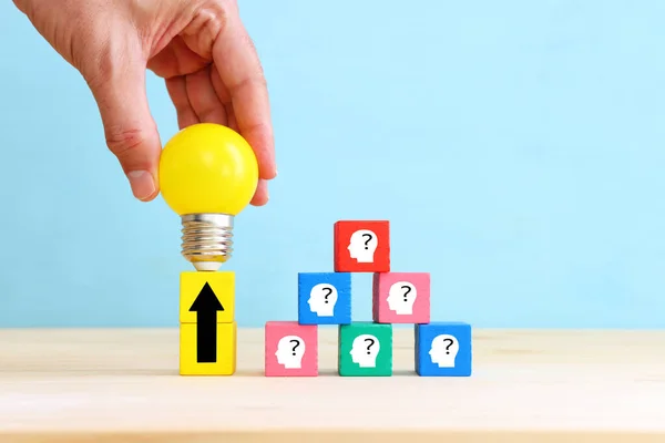 Education and human resource concept image. Creative idea and innovation. light bulb metaphor over blue background, wooden cubes and people icons