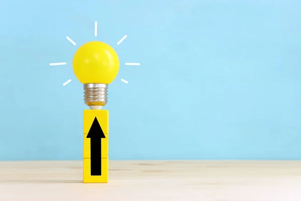 教育とビジネスのコンセプトイメージ 創造的なアイデアと革新 電球のメタファーと青い背景の矢印 — ストック写真