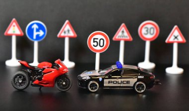 Yol işaretleri ve motosikletli oyuncak polis arabası.