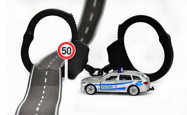 police toy car with handcuffs and road sign