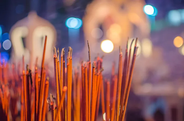 Red incense sticks burning in bokeh night