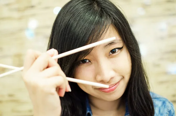 Asian young woman holding chopsticks