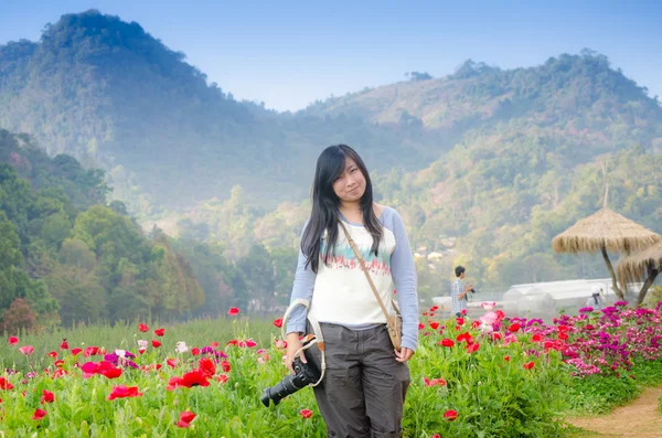 美丽的年轻女子草地上的花朵 — 图库照片